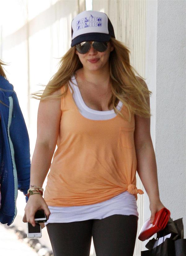 Hilary Duff Out in Los Angeles, August 30, 2012.  She's wearing a baseball cap and orange shirt as she leaves her personal trainers house