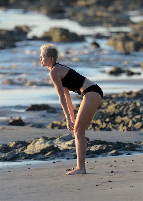 Miley Cyrus  yoga in black bikini on beach in Hawaii 1/24/13 