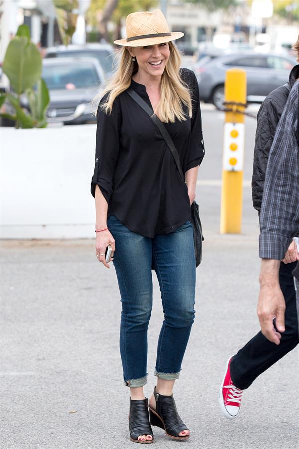 Julie Benz walking in jeans and a hat