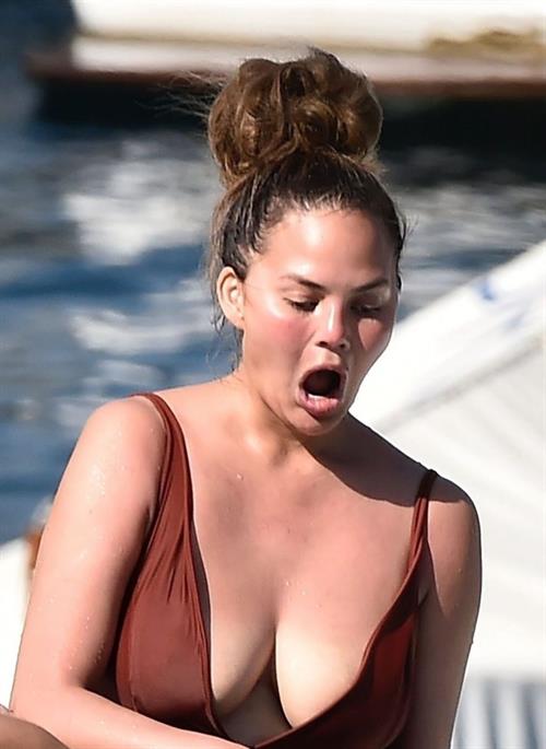 Chrissy Teigen Bikini Pictures Chrissy Teigen sexy cleavage and ass in a swimsuit with her husband John Legend seen by paparazzi.