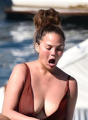 Chrissy Teigen sexy cleavage and ass in a swimsuit with her husband John Legend seen by paparazzi.
