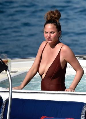 Chrissy Teigen sexy cleavage and ass in a swimsuit with her husband John Legend seen by paparazzi.

