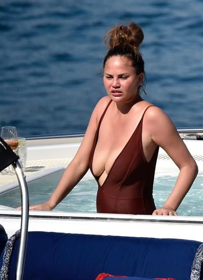 Chrissy Teigen sexy cleavage and ass in a swimsuit with her husband John Legend seen by paparazzi.
