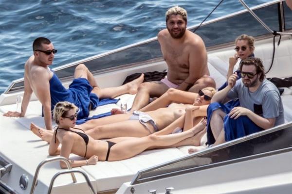 Kristen Stewart nude boobs caught topless by paparazzi tanning on a boat.
