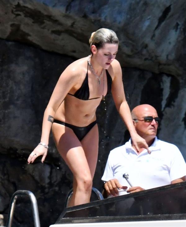 Kristen Stewart nude boobs caught topless by paparazzi tanning on a boat.
