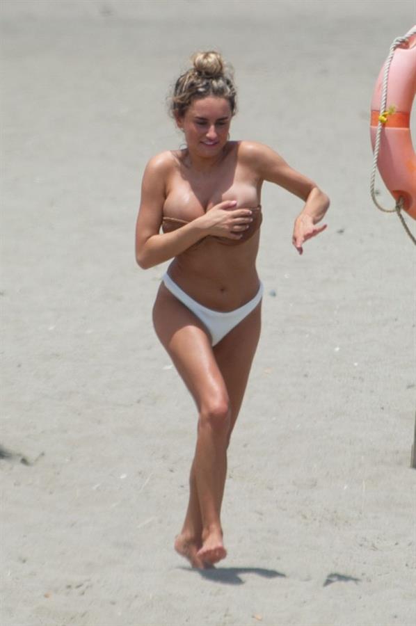 Amber Davies sexy boobs bouncing around in a loose bikini at the beach seen by paparazzi.

