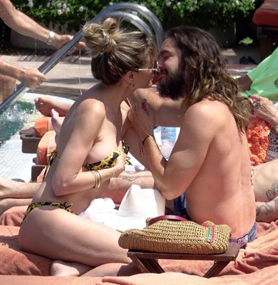 Heidi Klum nip slip in a sexy bikini seen by paparazzi and kissing her husband and flashing her boob.



