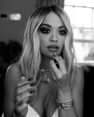 Rita Ora nude in just a robe backstage showing some nice cleavage.


