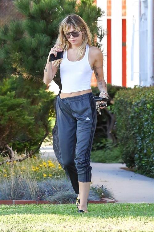 Miley Cyrus Pictures Miley Cyrus braless boobs in a slightly see through white top showing off her tits seen by paparazzi.