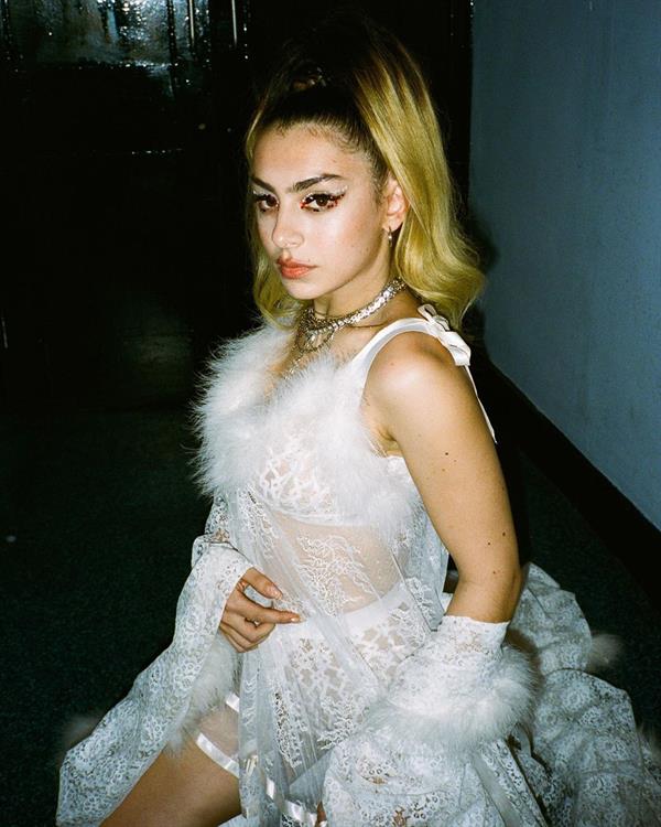 Charli XCX new photo of herself as a blonde and showing off her boobs in a see through white outfit.


