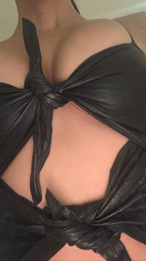 Kourtney Kardashian braless boobs in a revealing little black outfit showing nice cleavage closeup with her big tits.