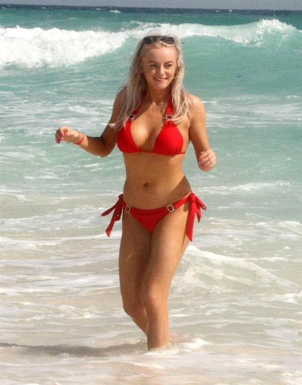 Katie McGlynn sexy ass in a red bikini also showing nice cleavage with her big tits on the beach in Mexico seen by paparazzi.