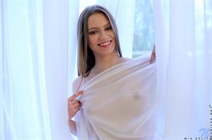 A white dress makes Mia Split seem like the picture of innocence, but don't let this amateur teen fool you. She knows exactly how hot she is as she peels off her clothes and uses a sheer curtain to tease you. Lifting one thigh as high as she can, she spreads her pussy for your viewing pleasure.
