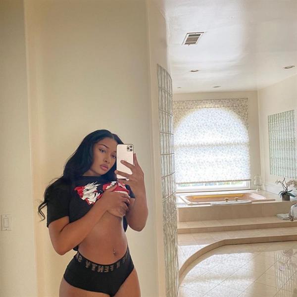 Megan Thee Stallion braless boobs in a little top pulling up her shirt holding her nude boobs as well as showing off her ass it booty shorts.