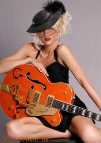 Olivia Paige in little black dress with guitar