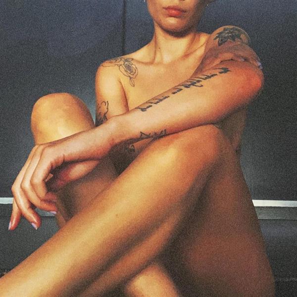 Halsey naked new photo sitting on the floor in her house posing to cover her nude boobs and pussy with her arm and legs.