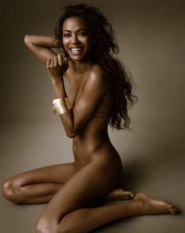 Zoe Saldana nude modelling photo posing fully naked barely covering her topless boobs and pussy.
