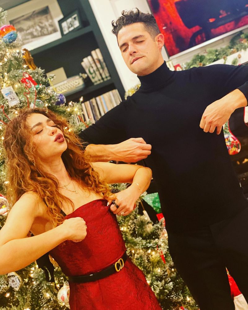 Sarah Hyland in front of her Christmas tree pinching her nipples in a sexy red dress.