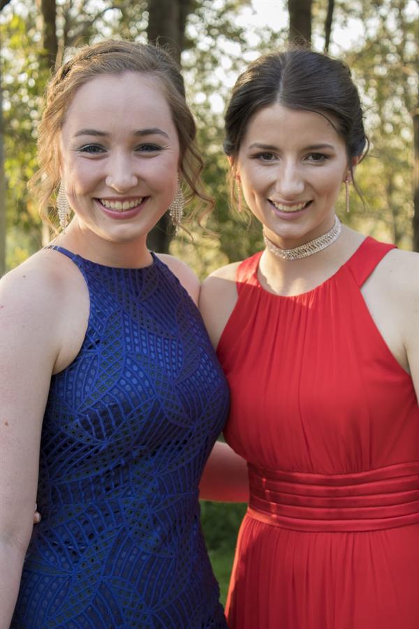 Caitlin Gooch in a choker and red dress (right) with Julia Self in a blue dress (left)