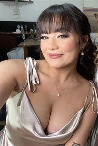 Rebekah Liepa in a low-cut bridesmaid dress, showing off her deep cleavage.