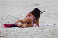 Claudia Romani in a purple thong bikini at the beach